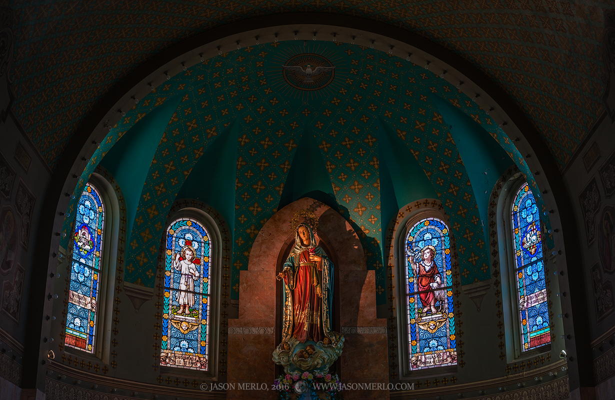 A statue of the Virgin Mary and stained glass windows in the apse at Immaculate Heart of Mary Church in San Antonio, one of the...