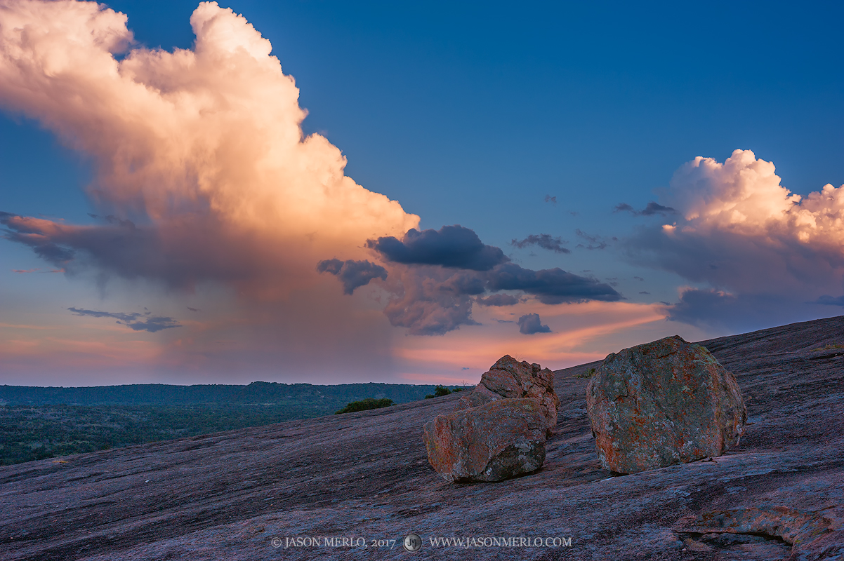 A summer rain shower in the distance at sunset at Enchanted Rock State Natural Area in Llano County in the Texas Hill Country...