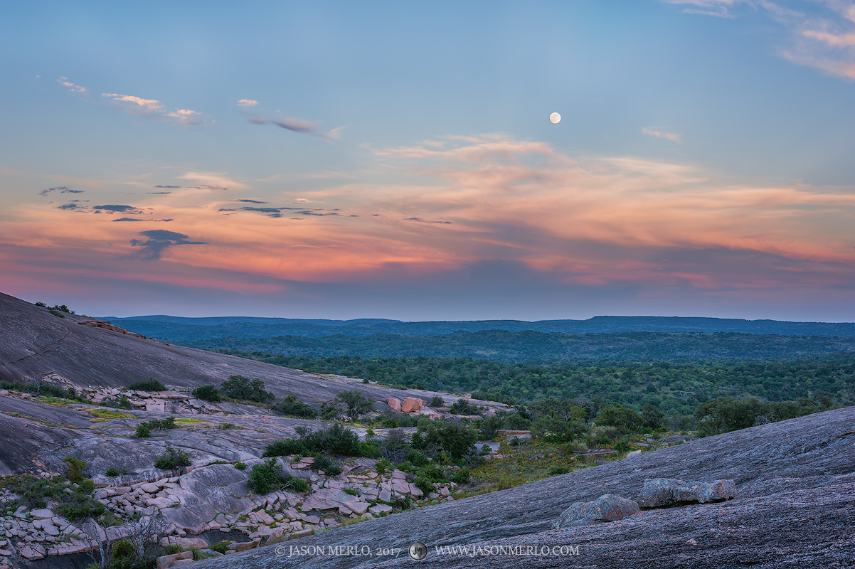 A full moon rising over Enchanted Rock State Natural Area in Llano County in the Texas Hill Country.