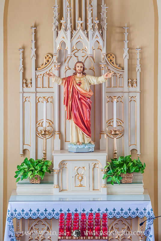 A side altar and votive candles at Queen of Peace Catholic Church in Sweet Home, one of the Painted Churches of Texas.