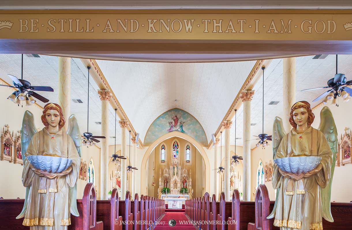 Angel statues flanking the main aisle at Queen of Peace Catholic Church in Sweet Home, one of the Painted Churches of Texas.
