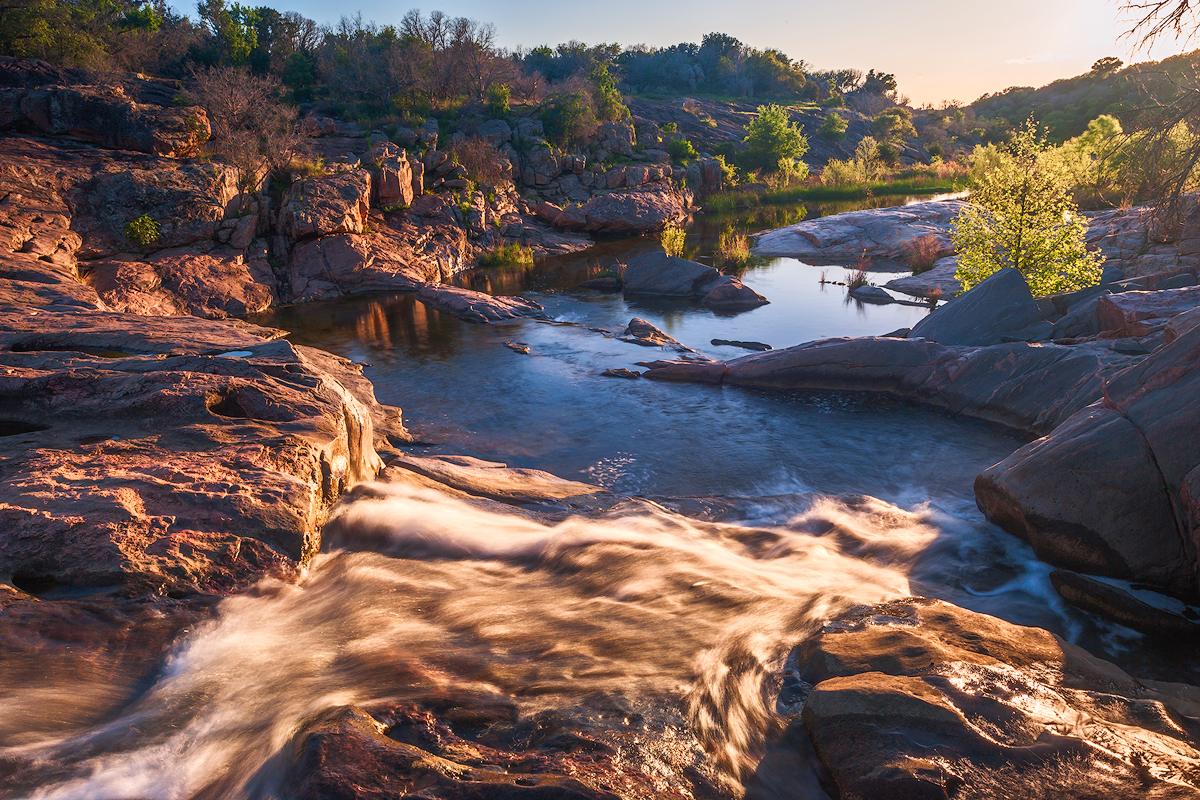 A waterfall on Spring Creek at sunset at Inks Lake State Park in Burnet County, Texas.